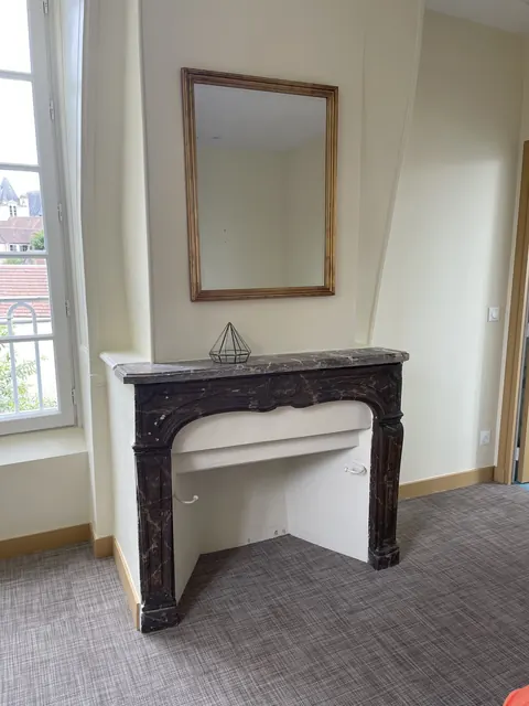 Cheminée de marbre et miroir doré dans une chambre
