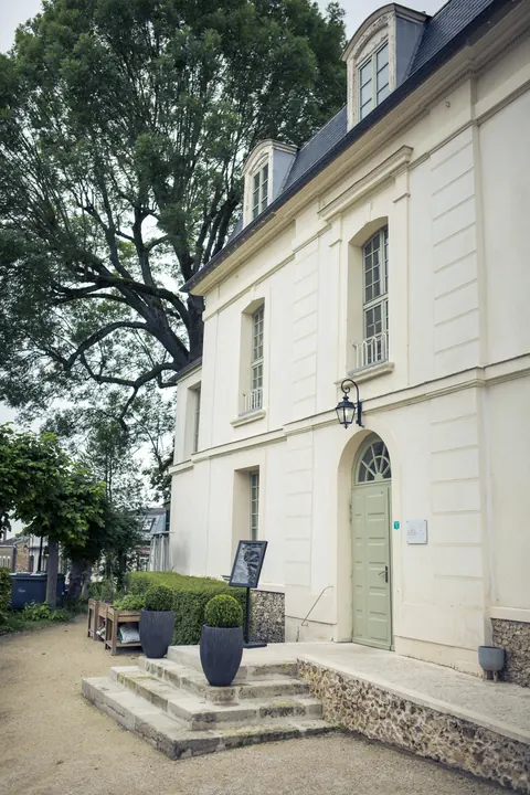 L'entrée de l'établissement : porte verte, lanterne et escalier de pierre