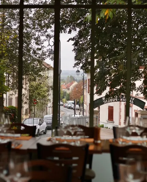 Vue du parc arboré depuis une table de la salle